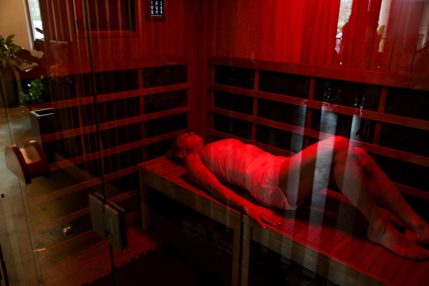 A member lying on the bench of the full spectrum infrared sauna at Your Journey Health Club
